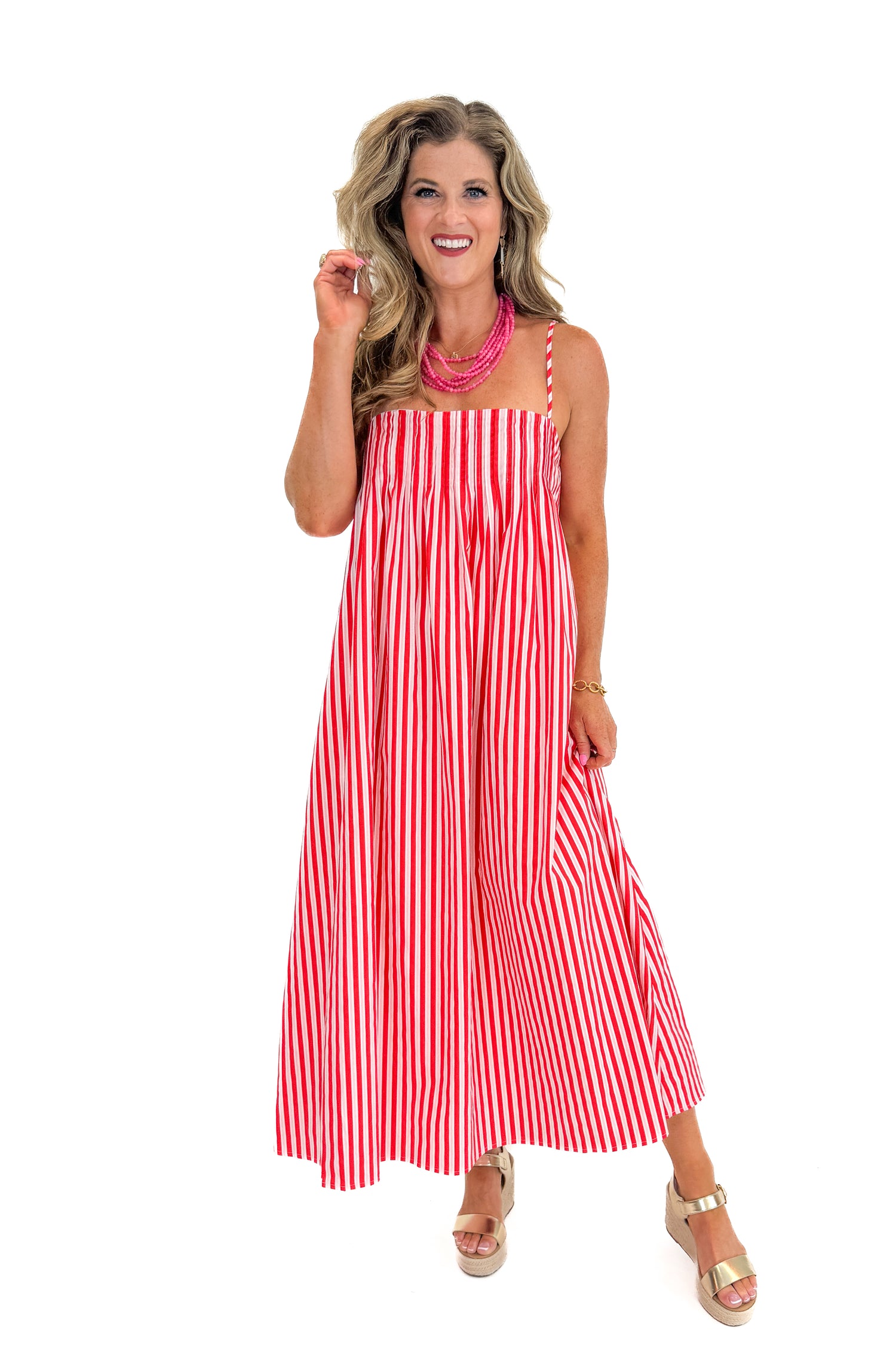 Front view of woman wearing Swagger Boutique’s Red &amp; Pink Striped Maxi Dress with sandals against white studio background.