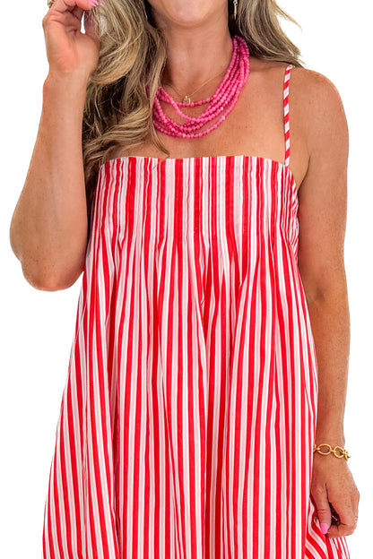 Front detail view of woman wearing Swagger Boutique’s Red &amp; Pink Striped Maxi Dress with sandals against white studio background.