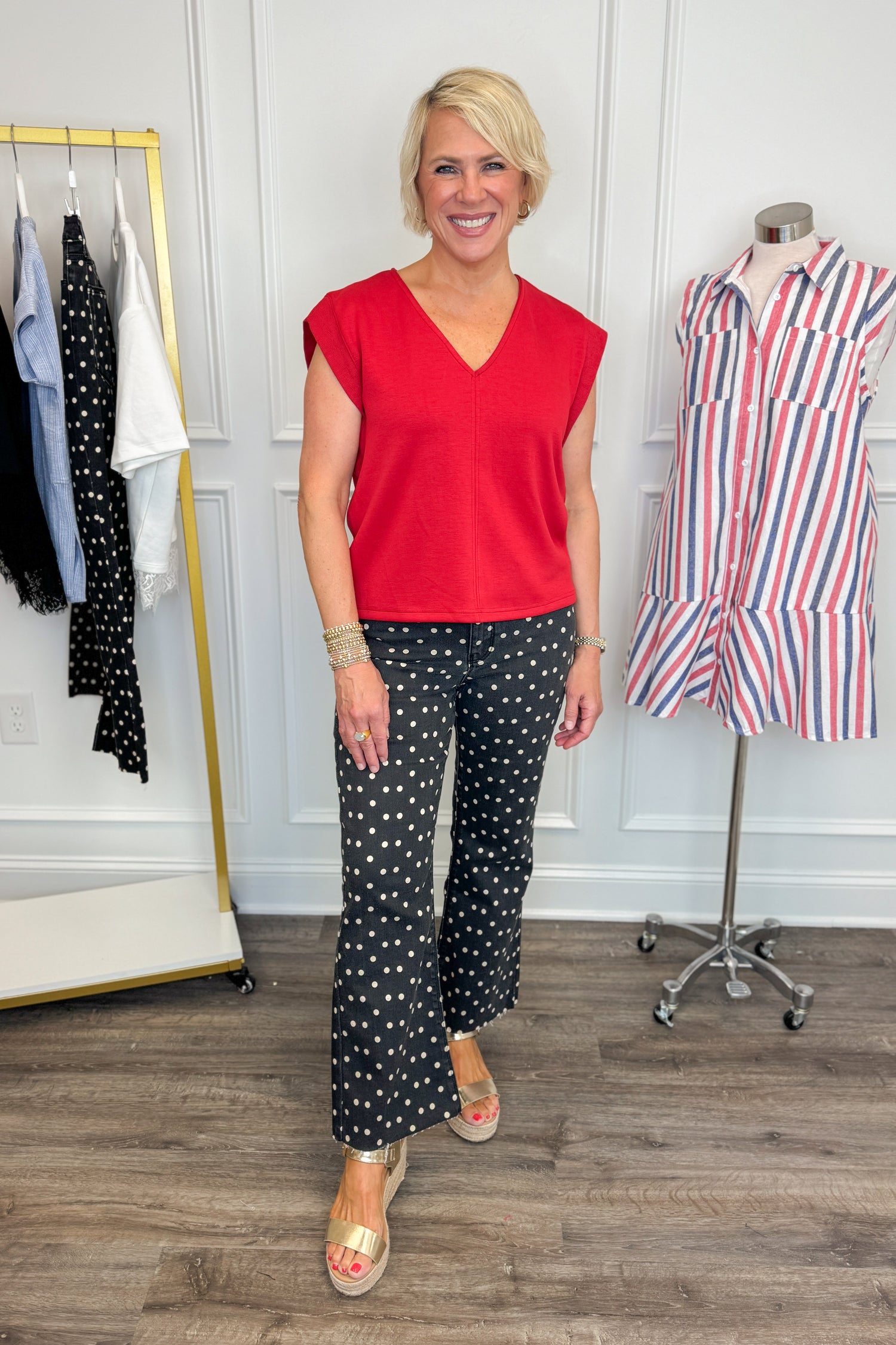 Front view of woman wearing Swagger Boutique’s Red V-Neck Tank by Entro with jeans against white studio background.