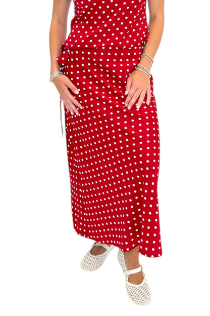 Front view of woman wearing Swagger Boutique’s Red &amp; White Polka Dot Midi Skirt with Red &amp; White Polka Dot Asymmetrical Tank against white studio background.