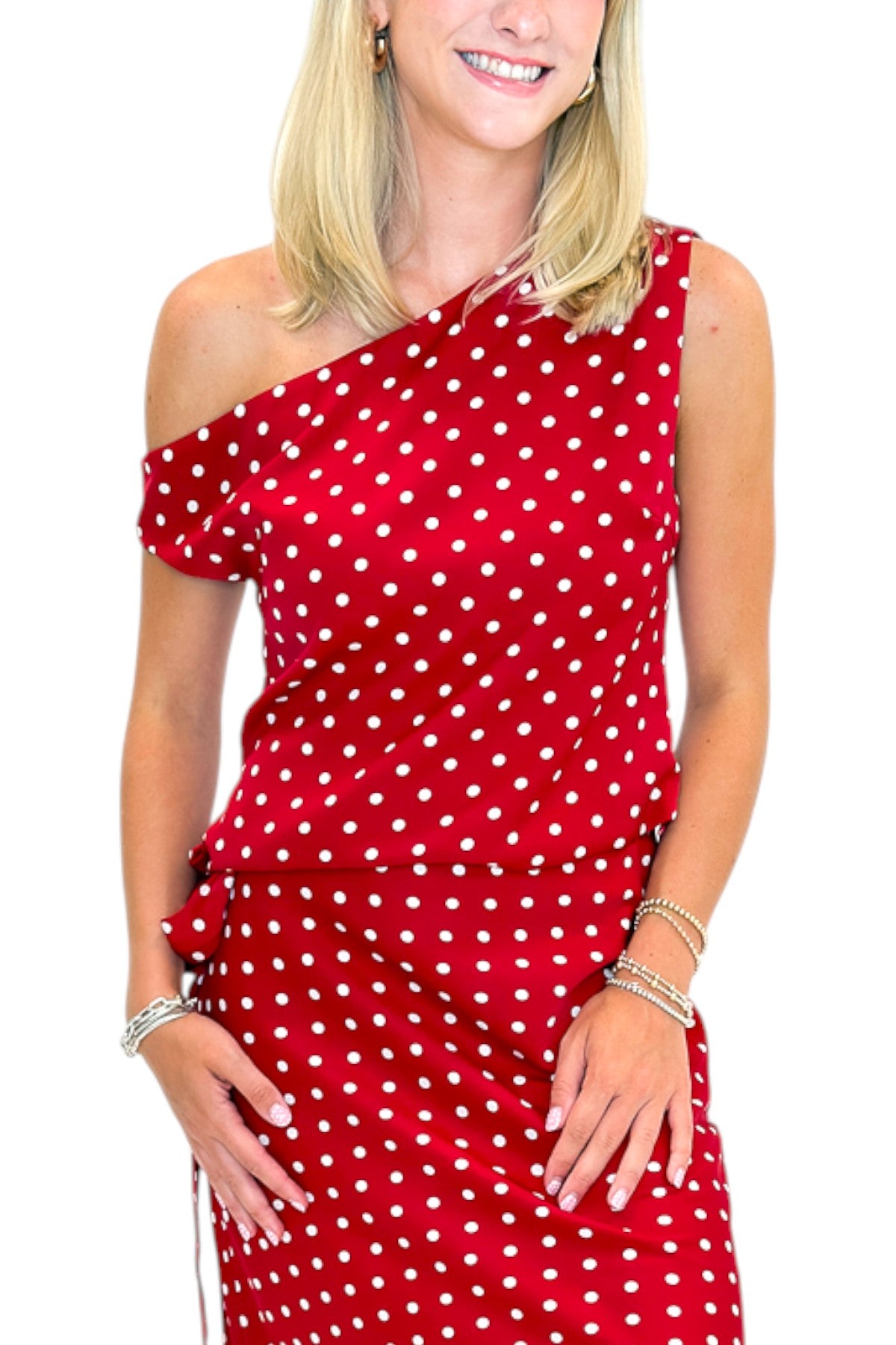Front detail view of woman wearing Swagger Boutique’s Red &amp; White Polka Dot Midi Skirt with Red &amp; White Polka Dot Asymmetrical Tank against white studio background.