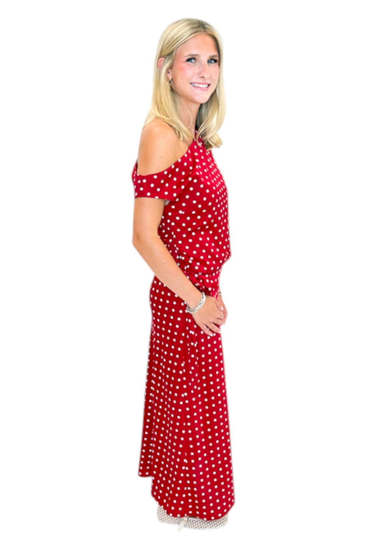 Side view of woman wearing Swagger Boutique’s Red &amp; White Polka Dot Midi Skirt with Red &amp; White Polka Dot Asymmetrical Tank against white studio background.