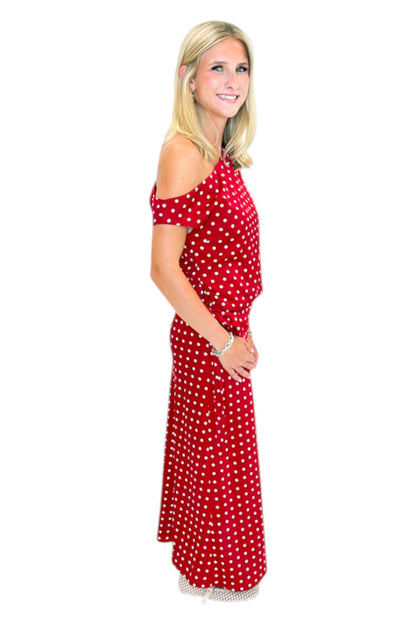 Side view of woman wearing Swagger Boutique’s Red &amp; White Polka Dot Midi Skirt with Red &amp; White Polka Dot Asymmetrical Tank against white studio background.
