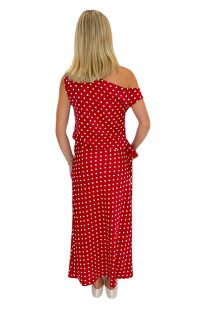 Back view of woman wearing Swagger Boutique’s Red &amp; White Polka Dot Midi Skirt with Red &amp; White Polka Dot Asymmetrical Tank against white studio background.