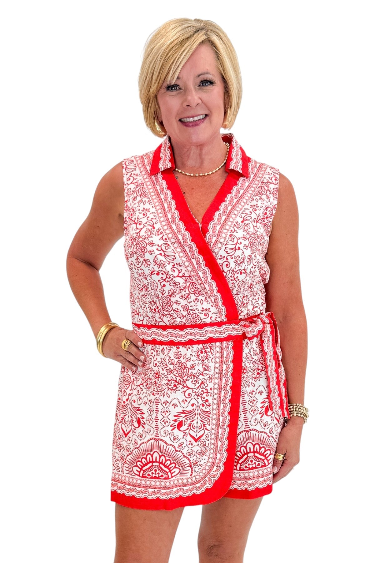 Front view of woman wearing Swagger Boutique’s Red &amp; White Printed Romper by Skies Are Blue with sandals against white studio background.