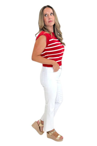 Side view of woman wearing Swagger Boutique’s Red &amp; White Striped Sleeveless Sweater with jeans against white studio background.