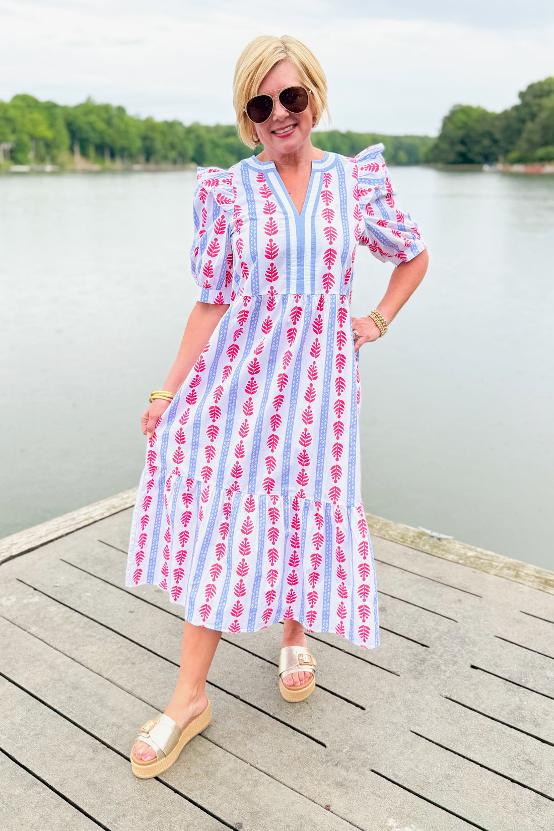Front view of woman wearing Swagger Boutique’s Red, White &amp; Blue Jonah Midi Dress by MudPie with Lulah Platform Sandals and sunglasses outside at the lake.