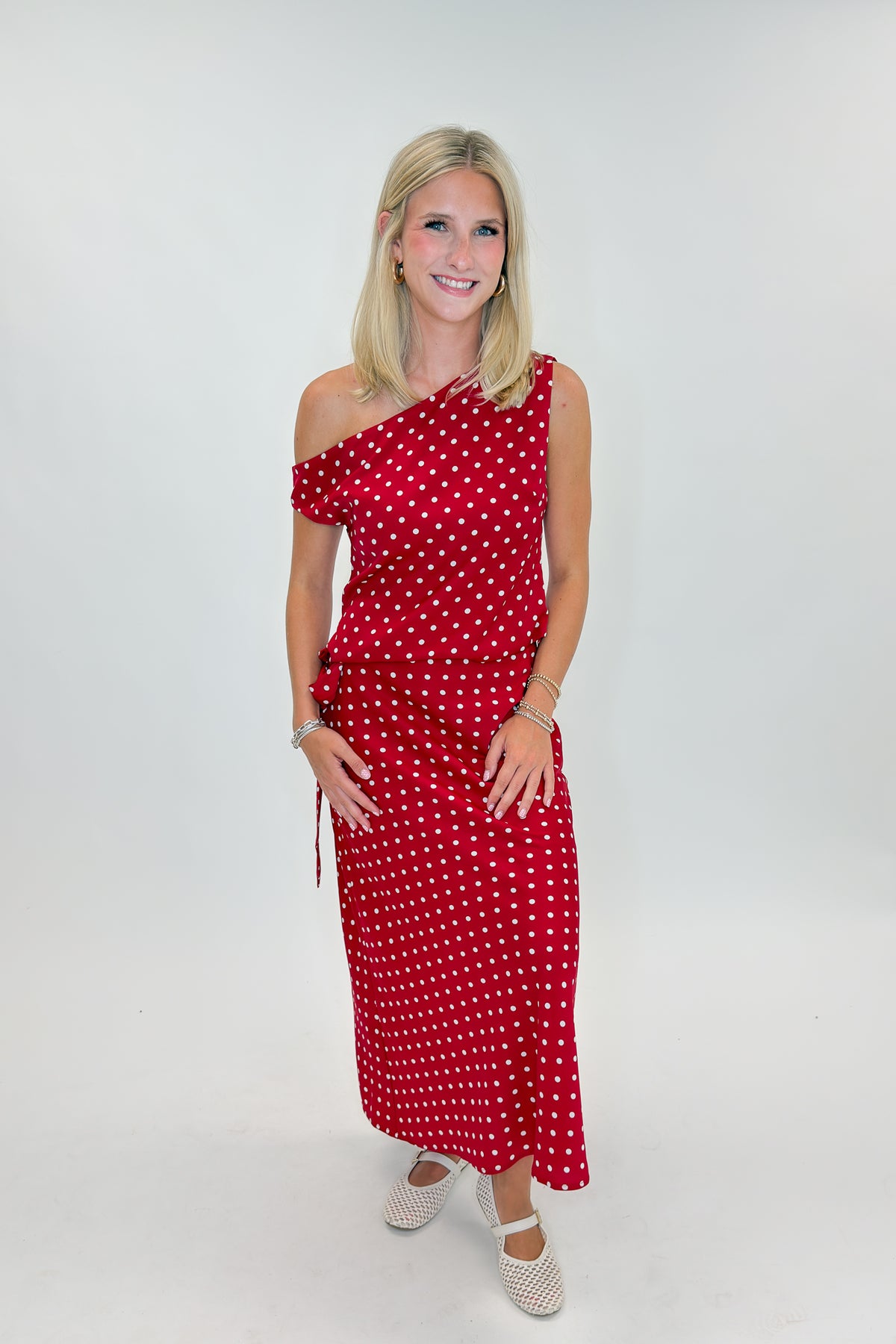 Front view of woman wearing Swagger Boutique’s Red &amp; White Polka Dot Midi Skirt with Red &amp; White Polka Dot Asymmetrical Tank against white studio background.