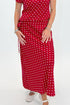 Front view of woman wearing Swagger Boutique’s Red & White Polka Dot Midi Skirt with Red & White Polka Dot Asymmetrical Tank against white studio background.