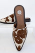 Regan- Cow Print Mule against white studio background.