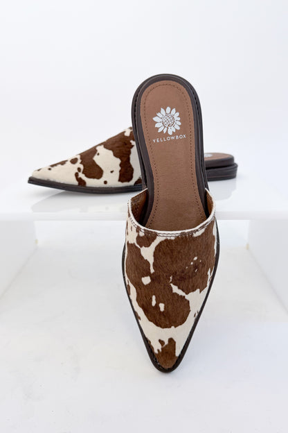 Regan- Cow Print Mule against white studio background.