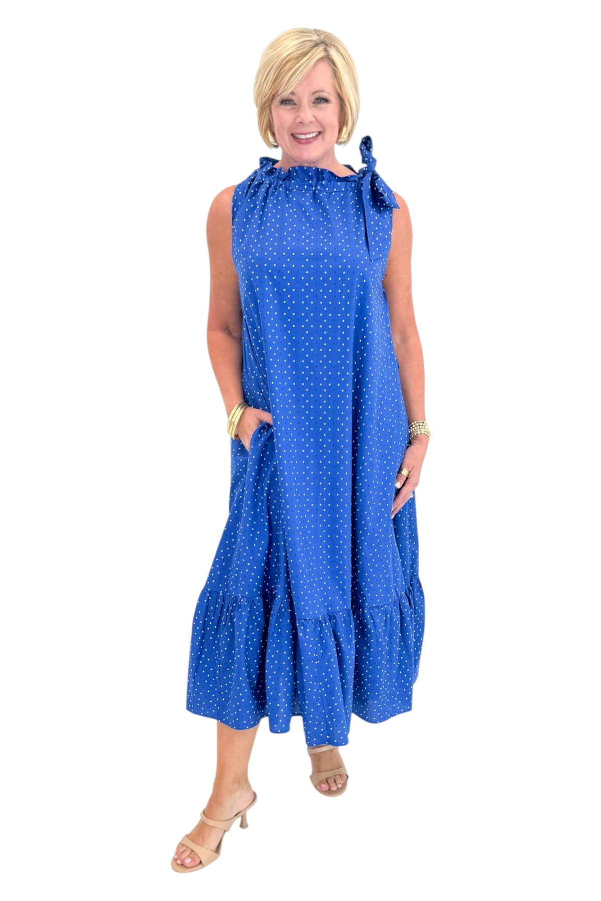 Front view of woman wearing Swagger Boutique’s Royal Blue Polka Dot Tue Neck Midi Dress against white studio background.