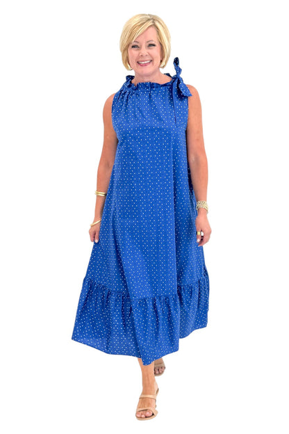 Front view of woman wearing Swagger Boutique’s Royal Blue Polka Dot Tue Neck Midi Dress against white studio background.