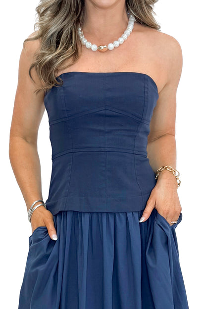Front detail view of woman wearing Navy Corset Lined Midi Dress against white studio background.