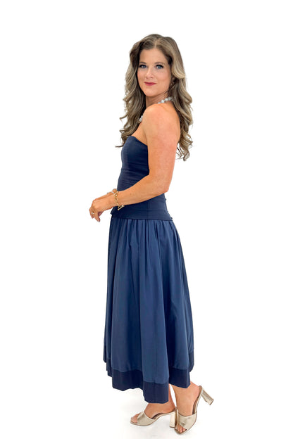 Side view of woman wearing Navy Corset Lined Midi Dress against white studio background.