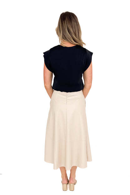 Back view of woman wearing Ecru Faux Leather Midi Skirt and black top against white studio background.