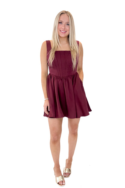 Front view of woman wearing Wine Corset Detail Satin Dress with heels against white studio background.