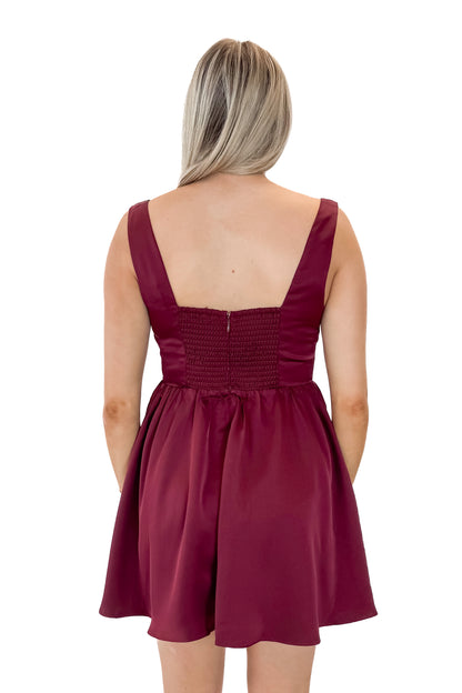 Back view of woman wearing Wine Corset Detail Satin Dress with heels against white studio background.