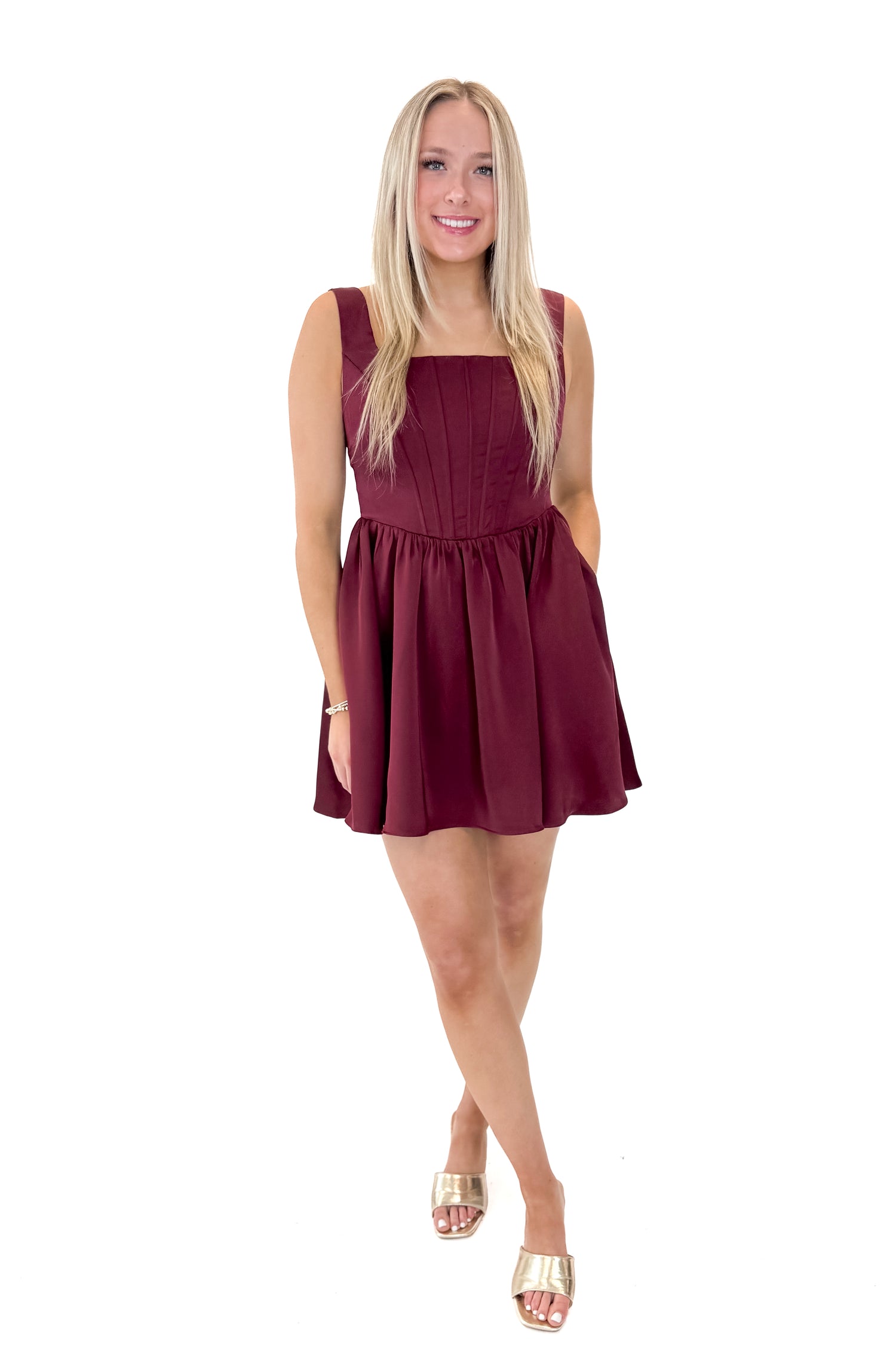 Front view of woman wearing Wine Corset Detail Satin Dress with heels against white studio background.