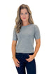 Front view of woman wearing Grey Short Sleeve Crewneck Sweater with jeans against white studio background.
