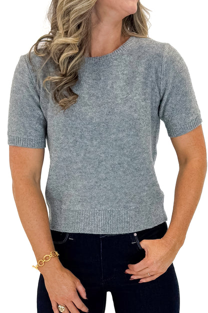 Front detail view of woman wearing Grey Short Sleeve Crewneck Sweater with jeans against white studio background.