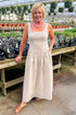 Front view of woman wearing Taupe Striped V-Waist Dress at a garden center.