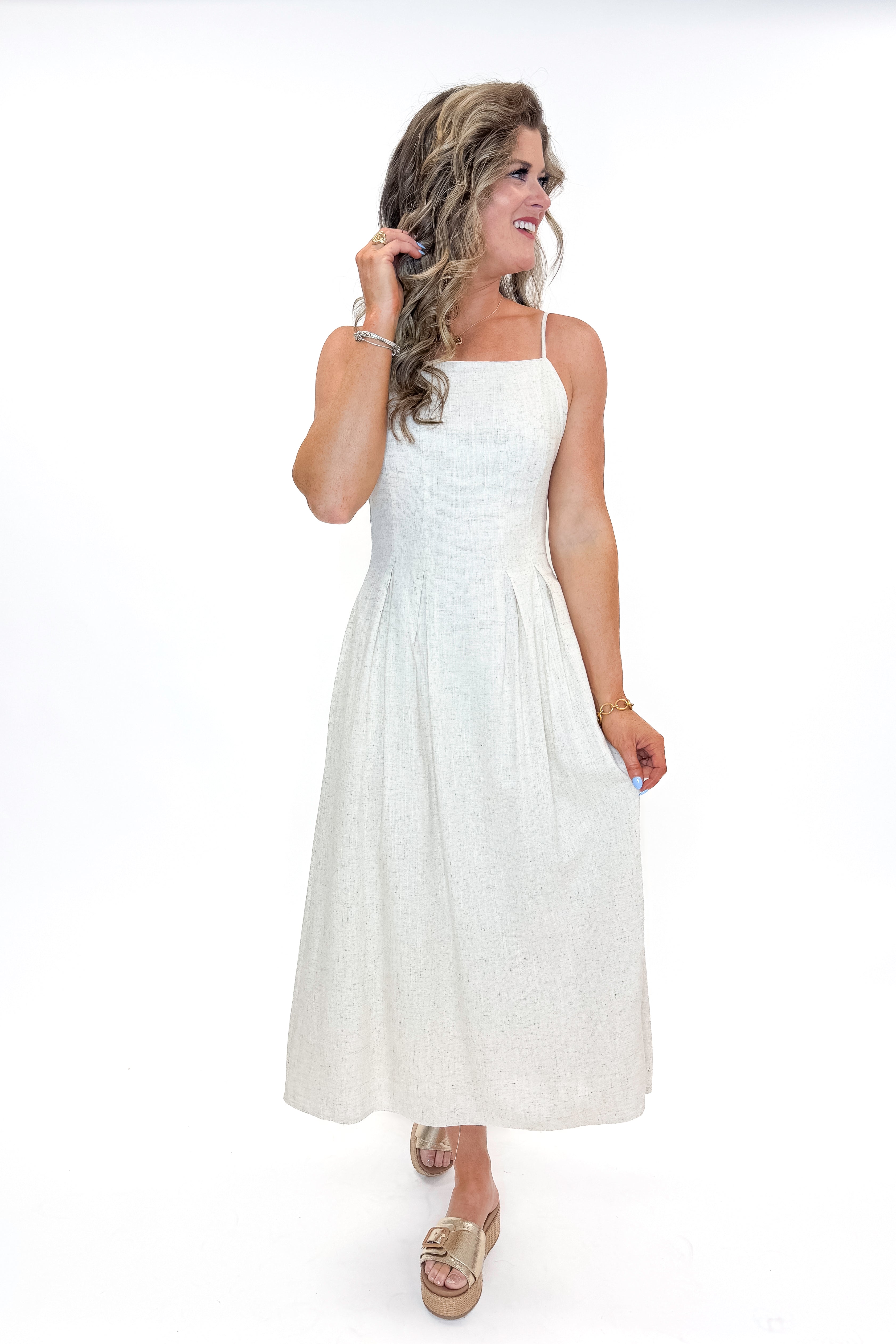 Front view of woman wearing Linen Pleat Detail Tank Dress with sandals against white studio background.