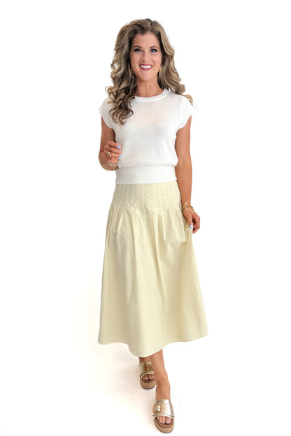 Front view of woman wearing top with Yellow Pleat Detail Midi Skirt against white studio background.