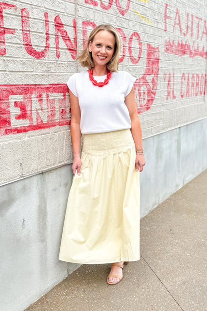 Front view of woman wearing top with Yellow Pleat Detail Midi Skirt standing outside.