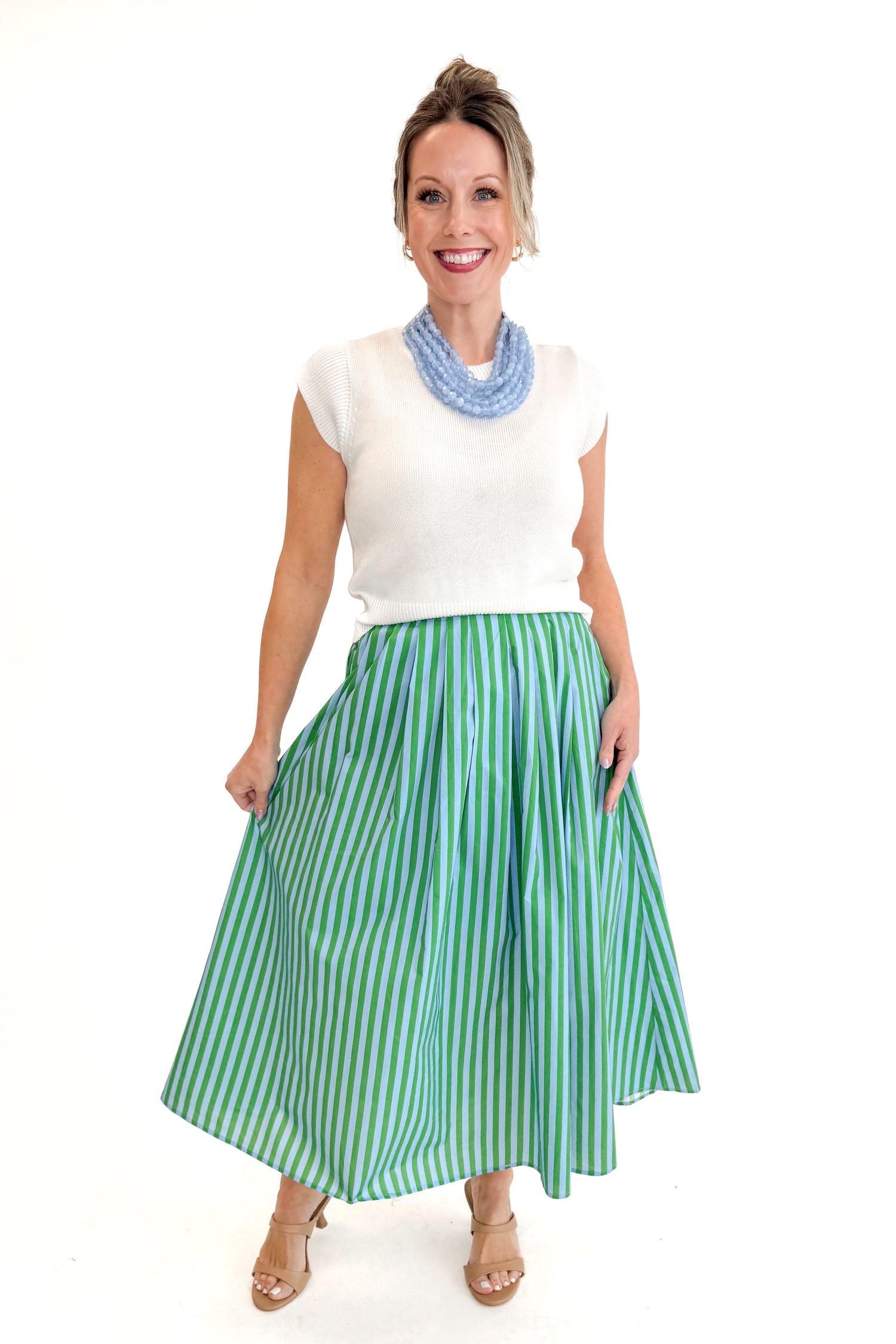 Front view of woman wearing Green &amp; Blue Striped Skirt by Entro with white sweater against white studio background.