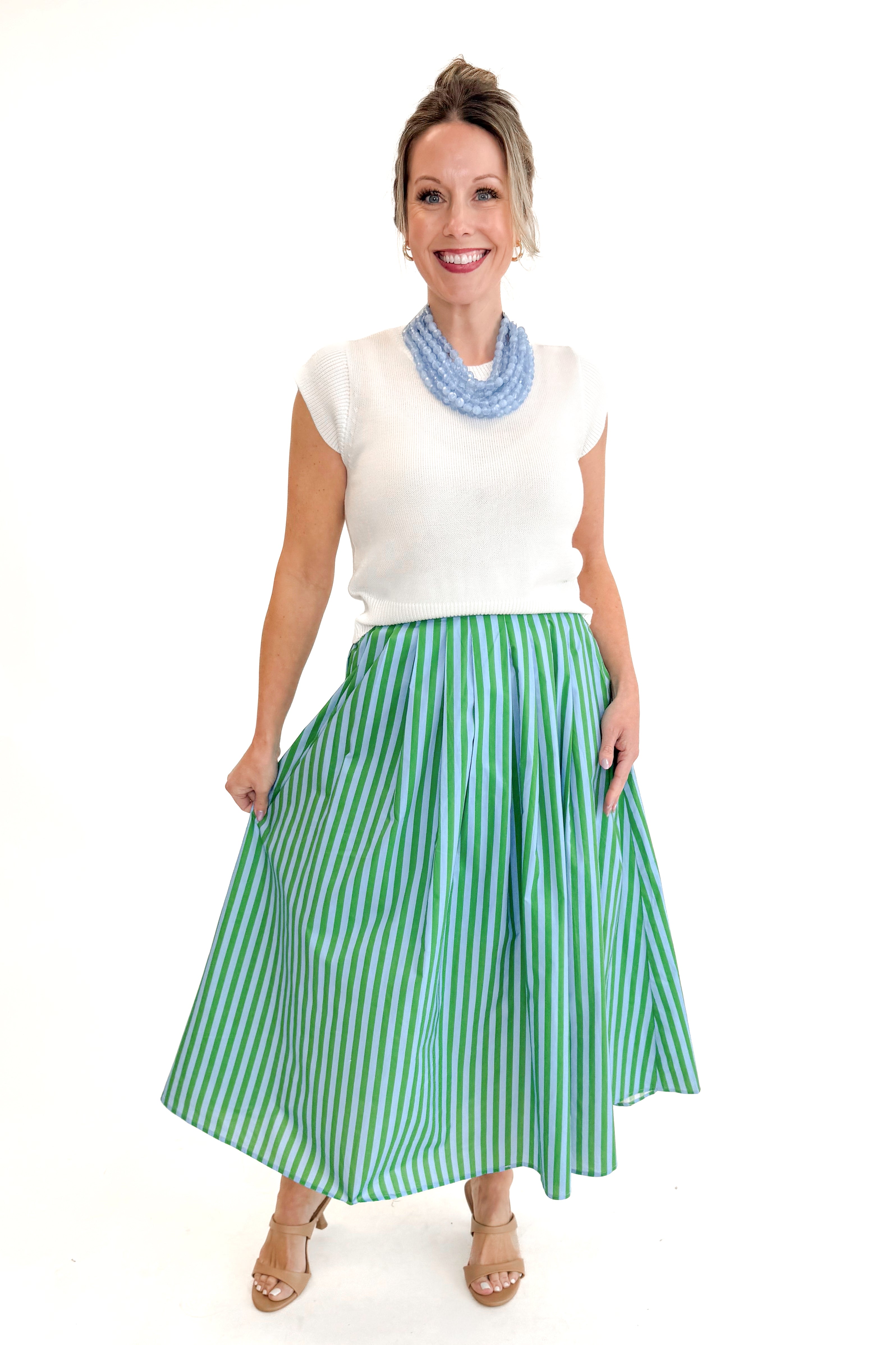 Front view of woman wearing Green &amp; Blue Striped Skirt by Entro with white sweater against white studio background.