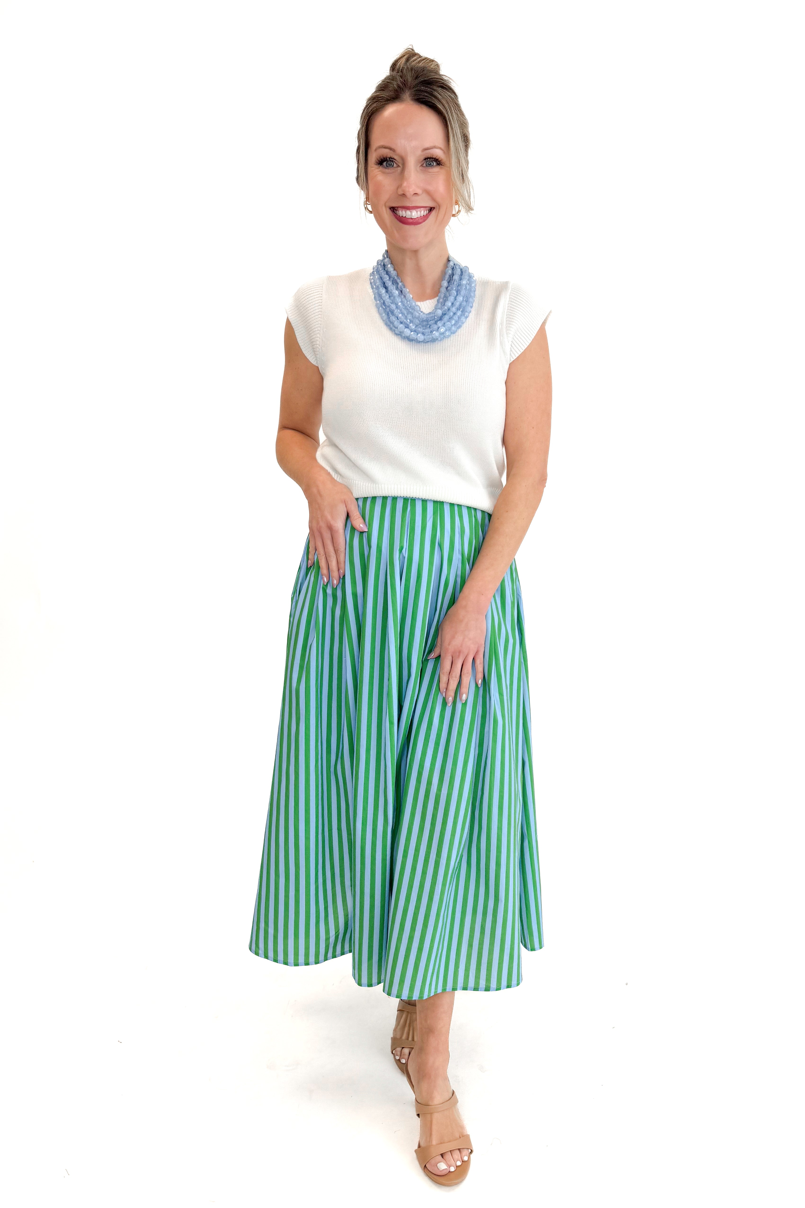 Front view of woman wearing Green &amp; Blue Striped Skirt by Entro with white sweater against white studio background.