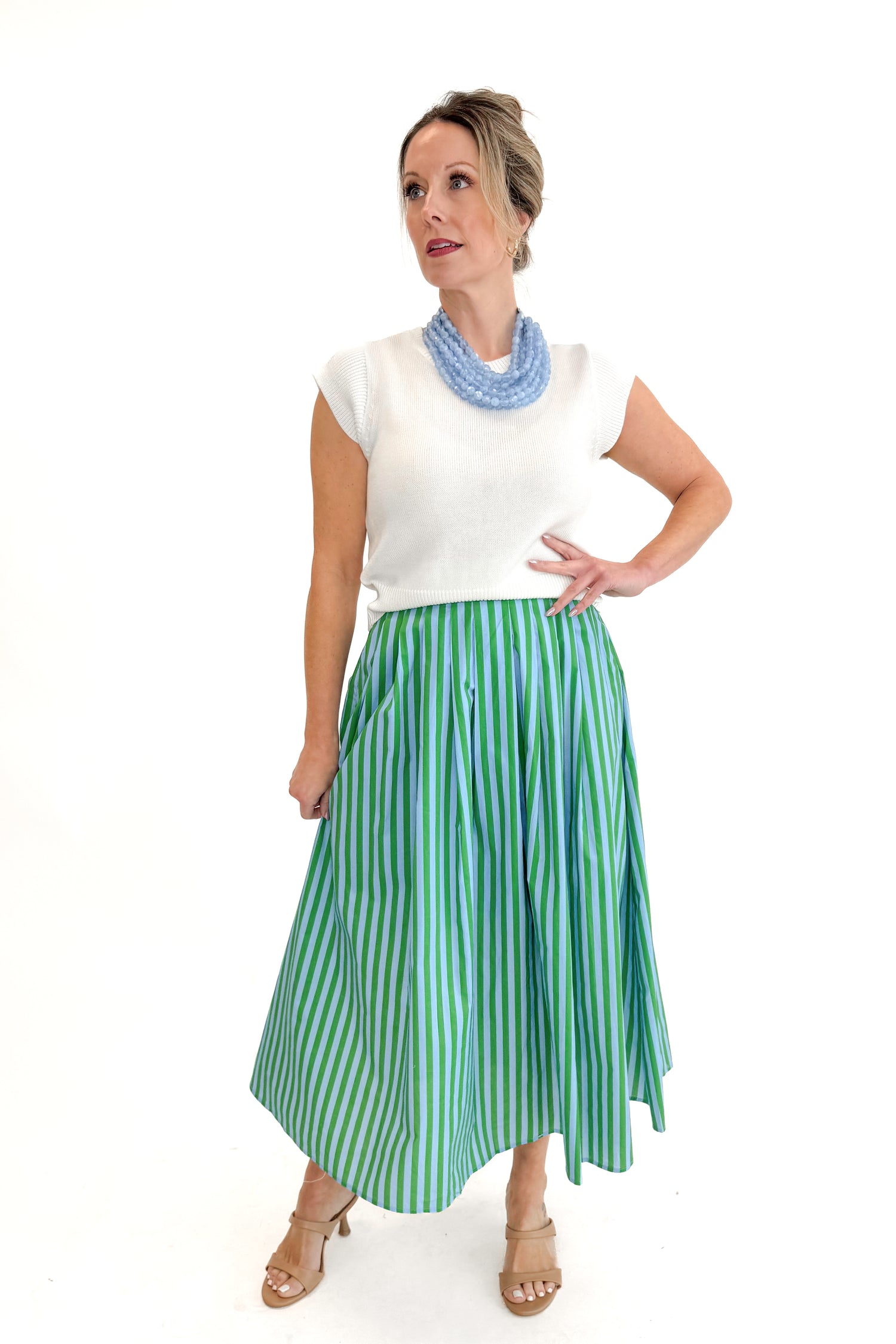 Front view of woman wearing Green &amp; Blue Striped Skirt by Entro with white sweater against white studio background.