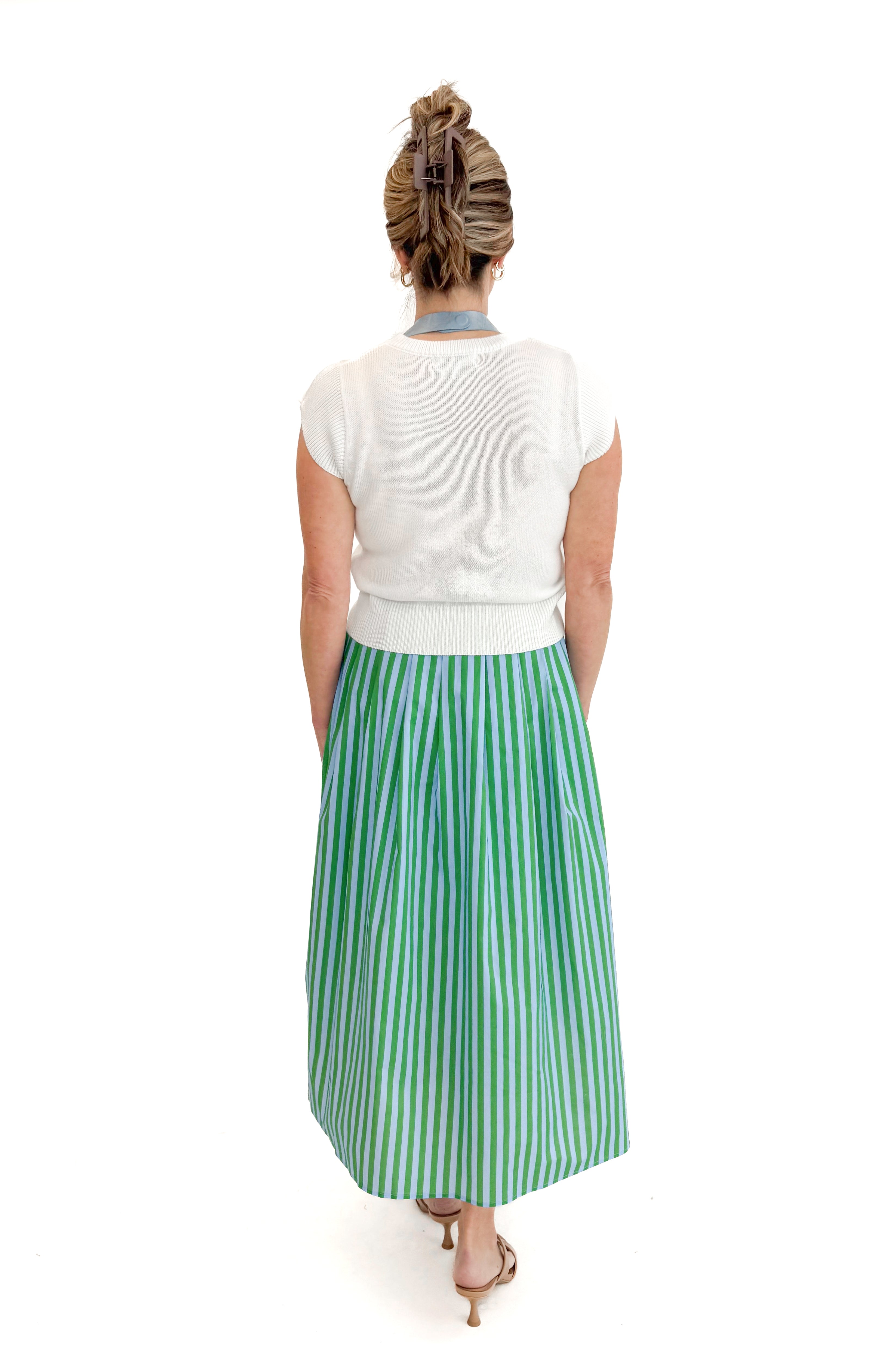Back view of woman wearing Green &amp; Blue Striped Skirt by Entro with white sweater against white studio background.