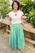 Back view of woman wearing Green & Blue Striped Skirt by Entro with white sweater at a garden center.