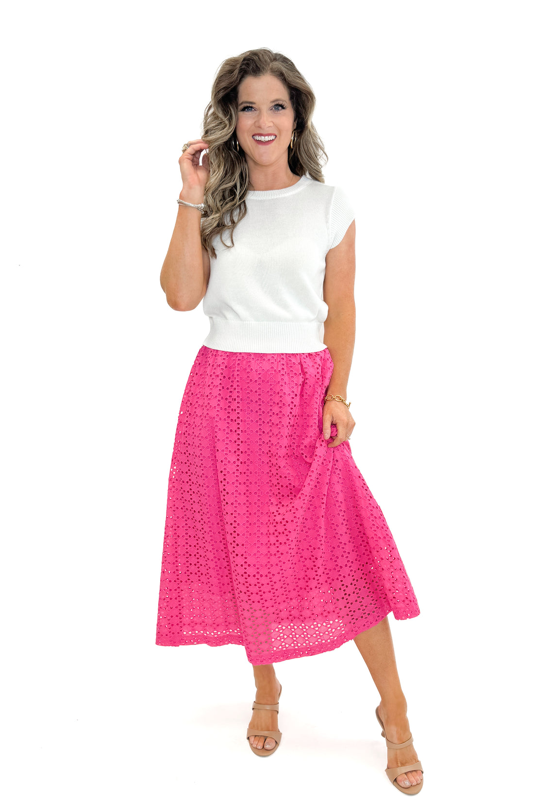 Front view of woman wearing white sweater with Hot Pink Eyelet Midi Skirt by Entro against white studio background.