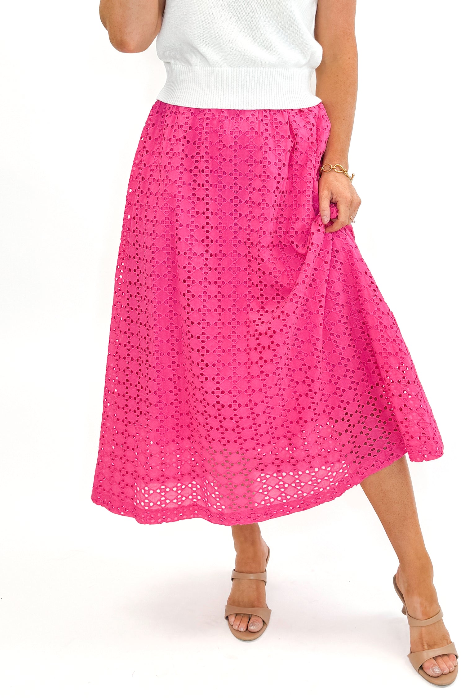 Front view of woman wearing white sweater with Hot Pink Eyelet Midi Skirt by Entro against white studio background.