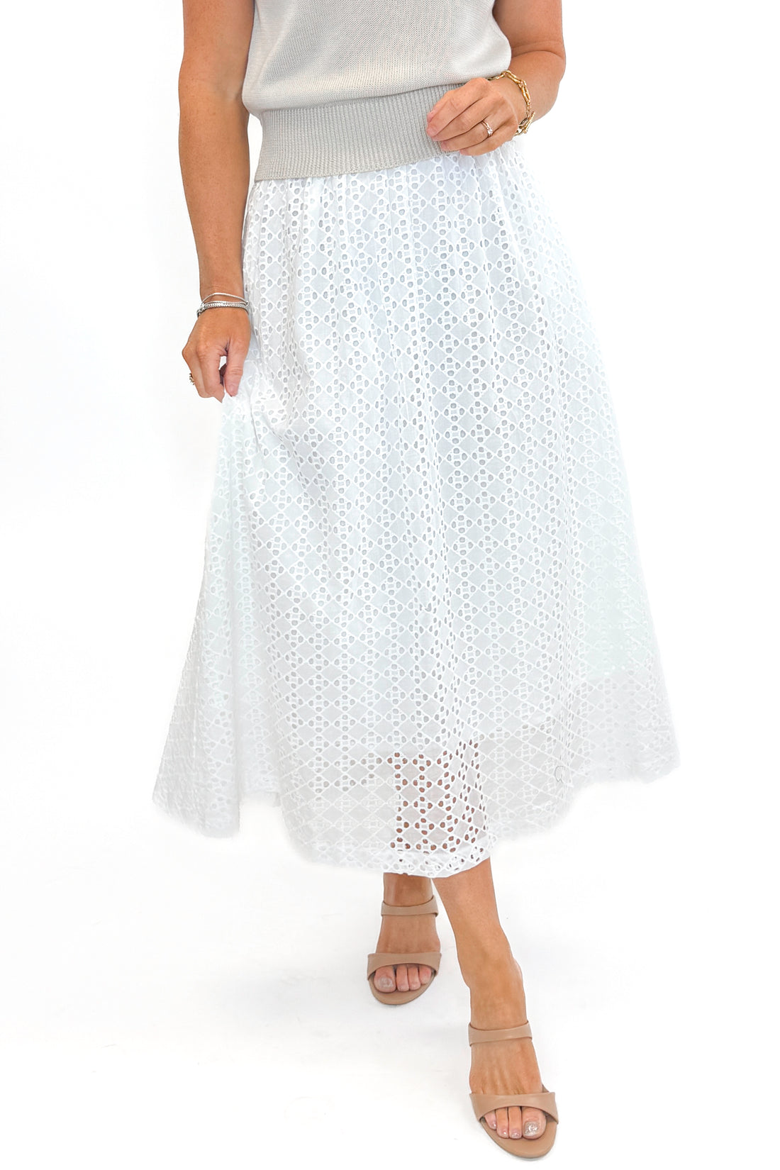 Front view of woman wearing Off White Eyelet Midi Skirt by Entro with sweater against white studio background.