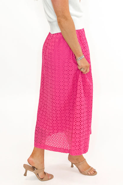 Side detail view of woman wearing white sweater with Hot Pink Eyelet Midi Skirt by Entro against white studio background.