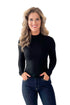 Front view of woman wearing Black Ribbed Mock Neck Top with jeans against white studio background.
