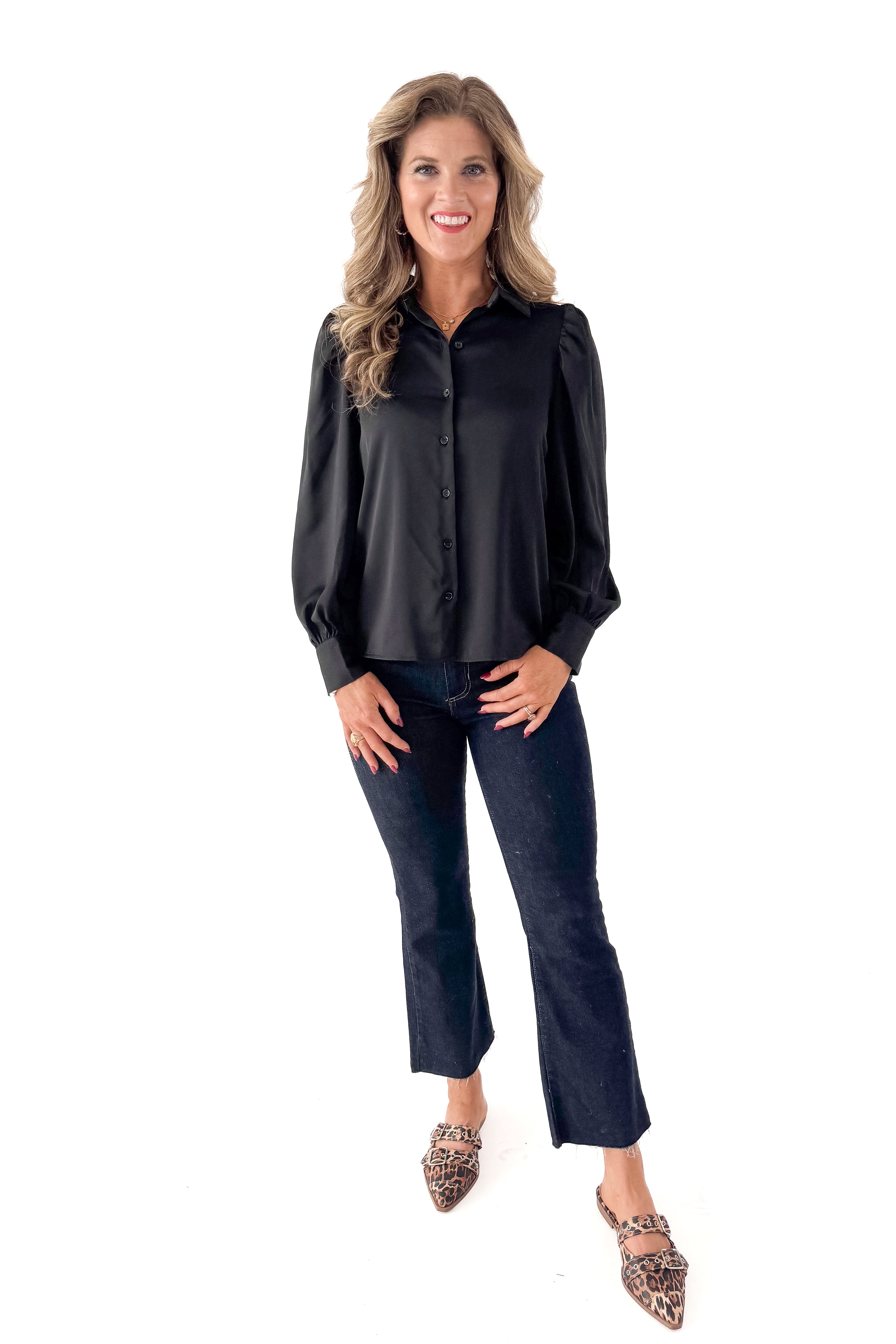 Front view of woman wearing Black Satin Button Up Top with jeans against white studio background.