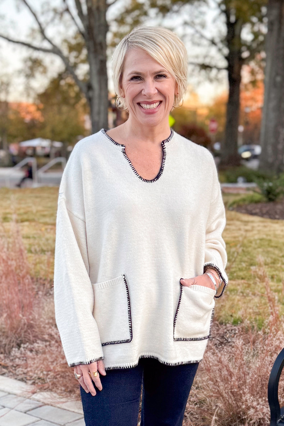 Front view of woman wearing Cream Pocket &amp; Stitch Detail Sweater with jeans outside.