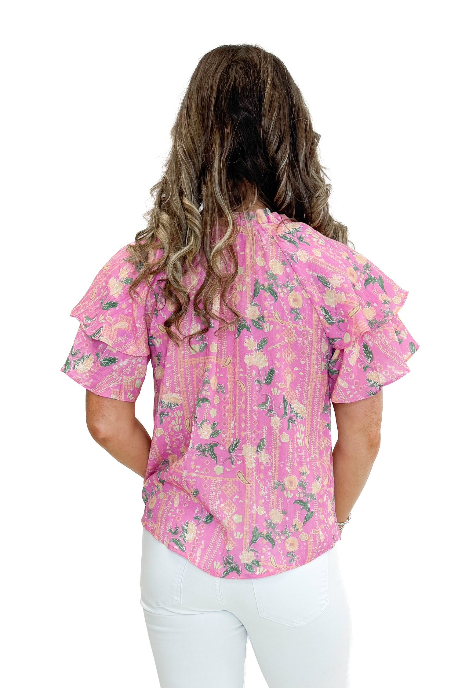 Back view of woman wearing Pink Floral Printed Ruffle Sleeve Top with jeans against white studio background.