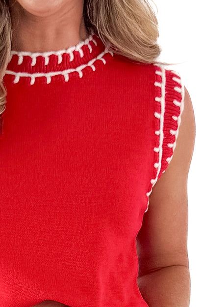 Detailed Front view of woman wearing red sleeveless sweater with white studio background.