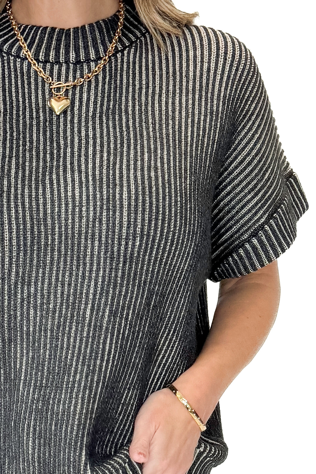 Front detail view of woman wearing Black &amp; White Ribbed Short Sleeve Sweater with jeans against white studio background.