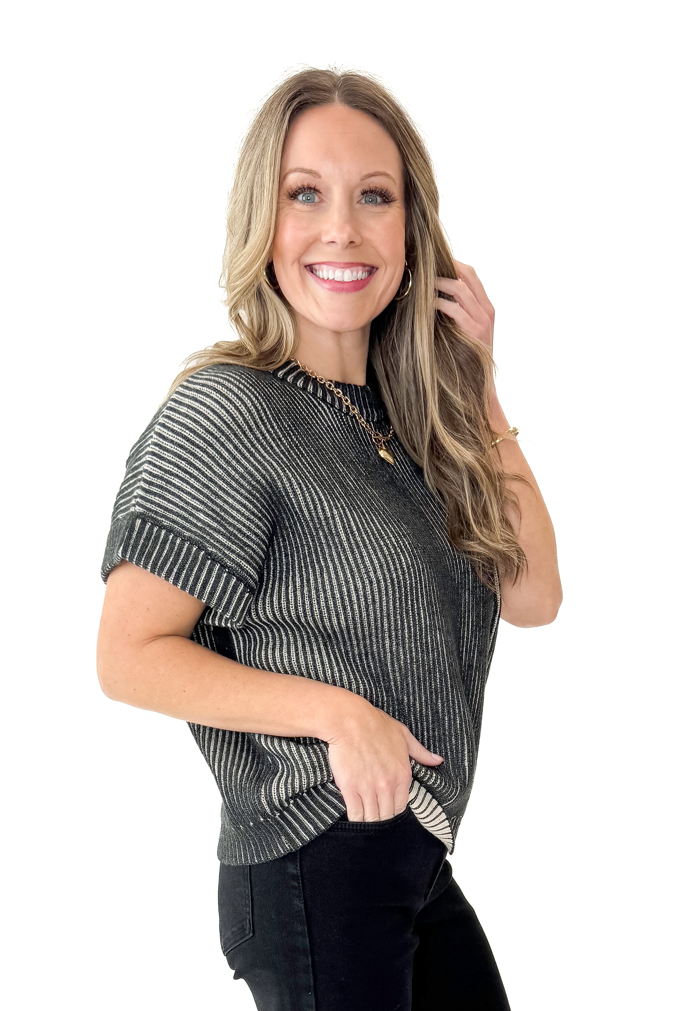 Side view of woman wearing Black &amp; White Ribbed Short Sleeve Sweater with jeans against white studio background.