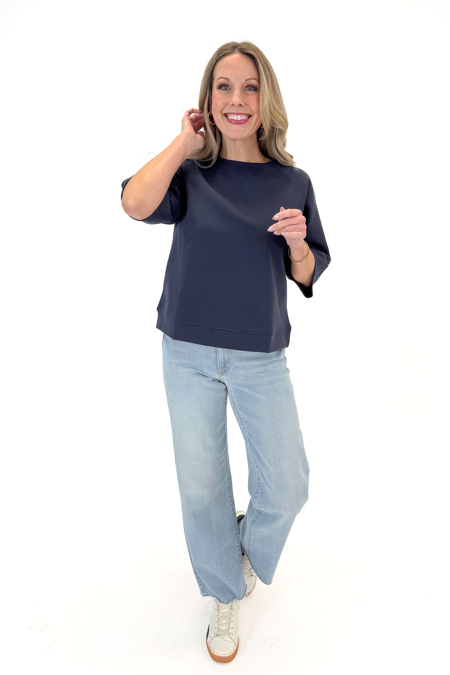 Front view of woman wearing Navy Super Soft Half Sleeve Top with jeans against white studio background.