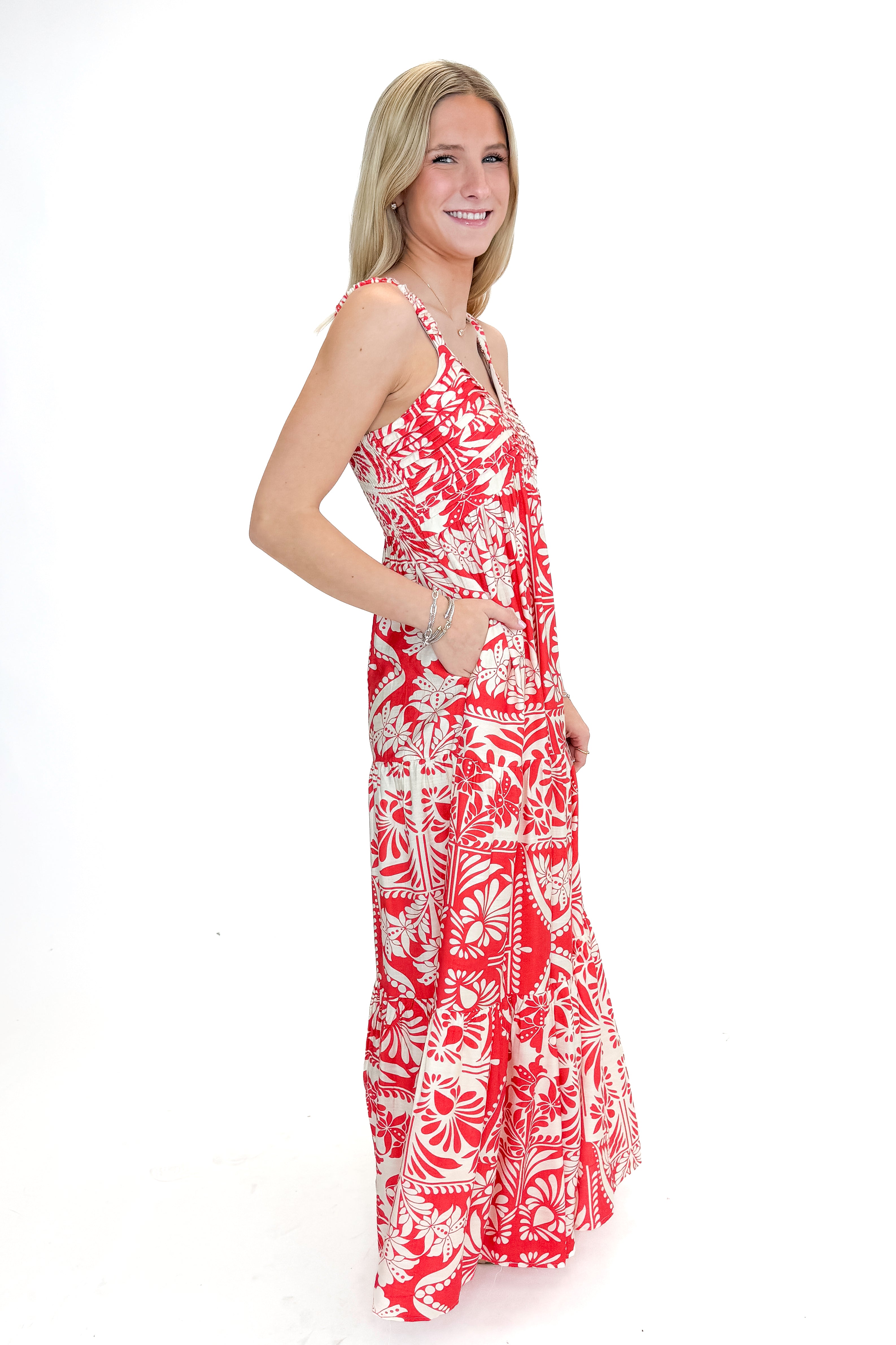 Side view of woman wearing Red Printed Sleeveless V-neck Maxi Dress against white studio background.