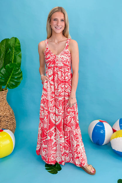 Front view of woman wearing Red Printed Sleeveless V-neck Maxi Dress against blue beachy background.