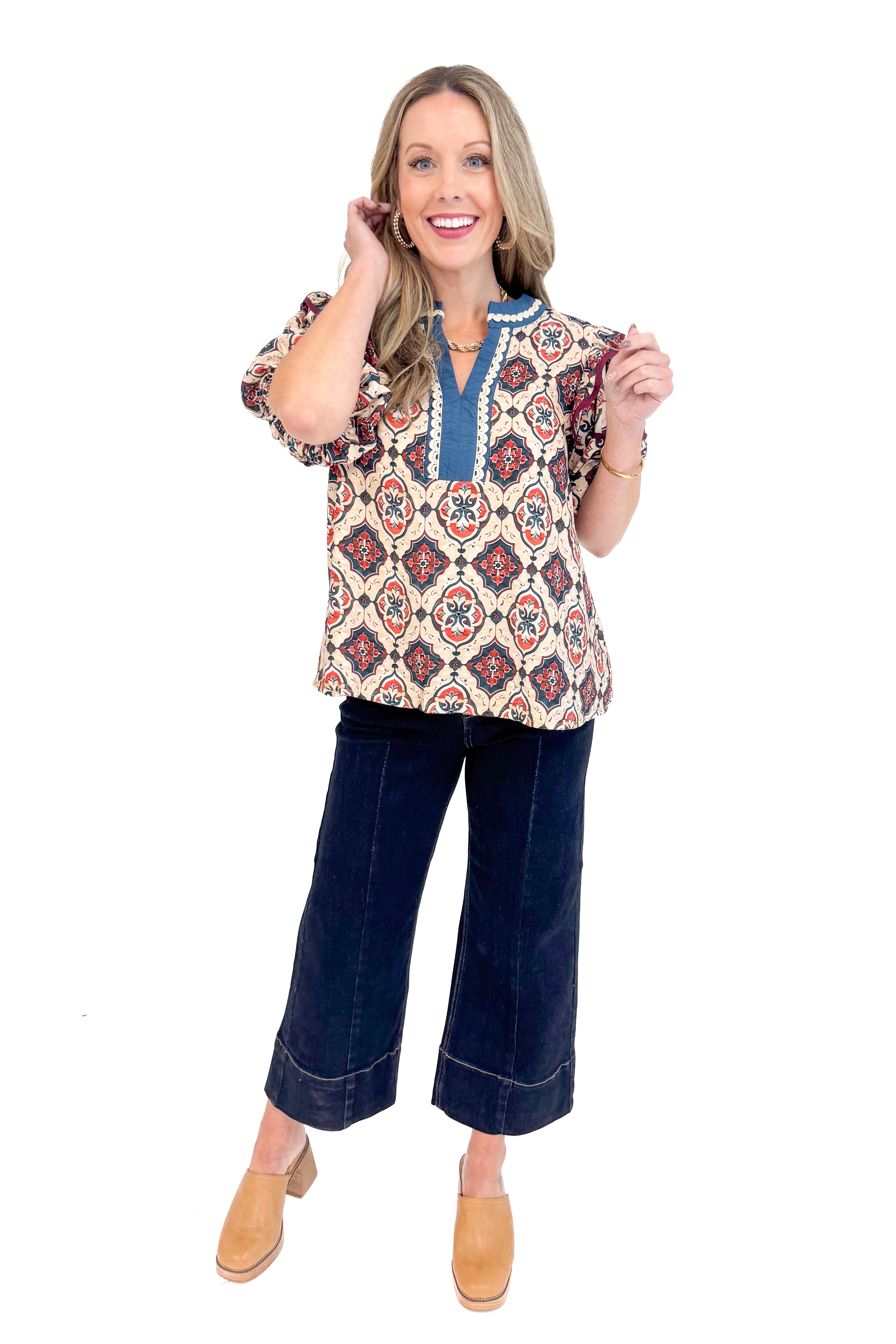 Woman wearing Teal and Wine Printed V-neck Top and jeans with white background.